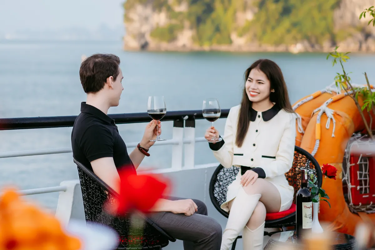 Guests enjoying sunset party on deck during Halong Bay 1 day cruise