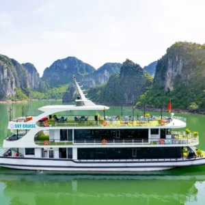 Sky Cruise boat anchored on calm green water surrounded by Halong Bay limestone mountains