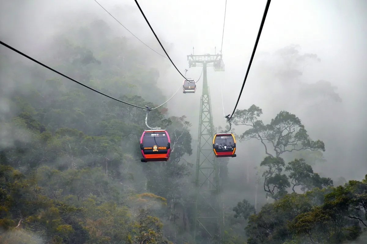 A cable car ascending through thick fog and forest toward Ba Na Hills near Da Nang