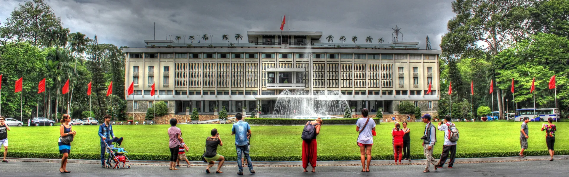 The Independence Palace facade with fountain and Vietnamese flags in Ho Chi Minh City