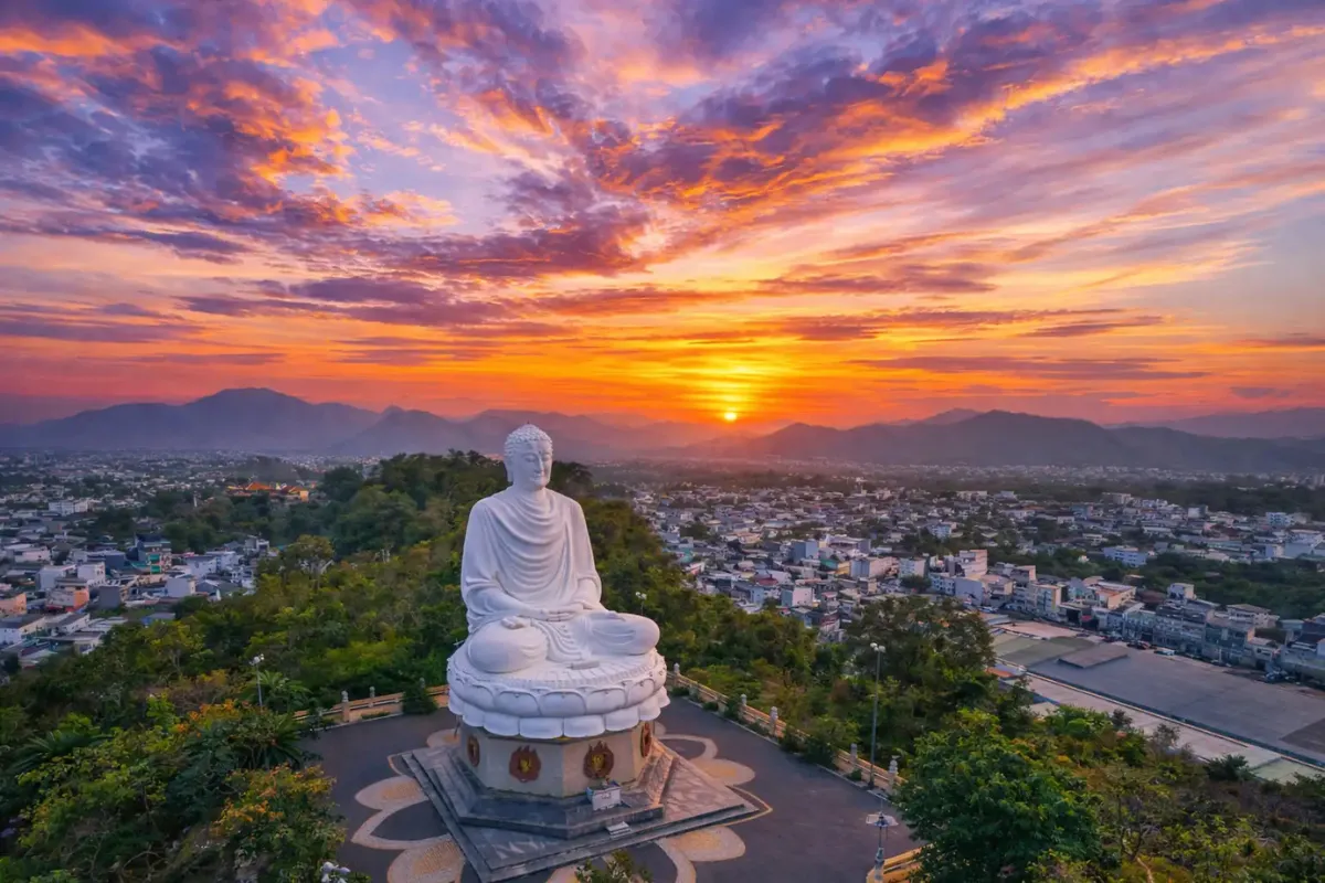 Giant white Buddha statue overlooking Nha Trang City at sunset from Long Son Pagoda hillside