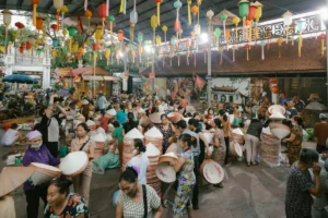 Vendors carrying stacks of conical hats through a busy market near Hanoi's craft villages