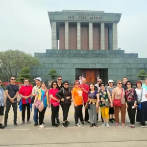 Large tour group posing in front of Ho Chi Minh Mausoleum on a Hanoi city tour half day