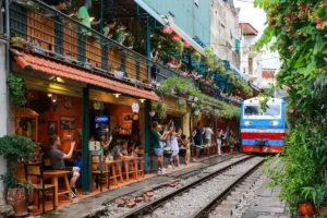 Train passing directly beside cafes and diners on Hanoi's narrow Train Street